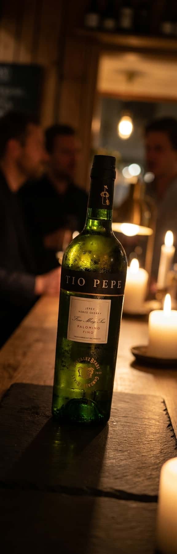 Et avlangt hvitt glass med iskald fino sherry, kondens på utsiden, i sommerlig utendørs setting (Tio Pepe Fino)